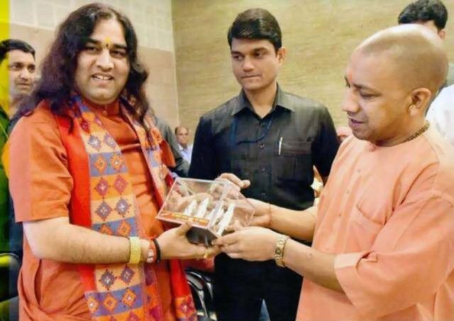 Devkinandan Thakur receiving award from Yogi Adityanath
