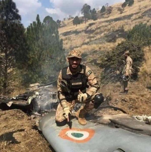 A Pakistani Soldier Sitting On The Wreckage Of A Jet Plane Of The Indian Air Force