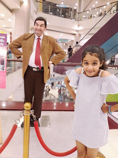 Syna Anand posing with Mr. Bean's statue