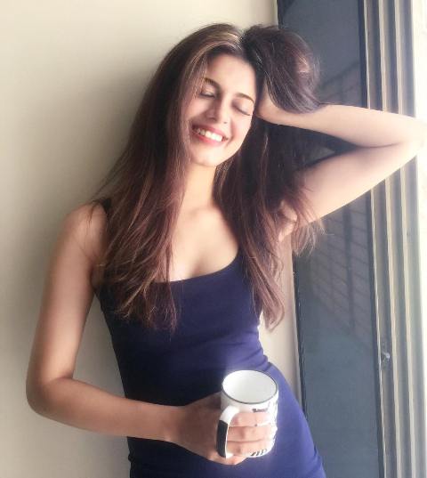 Asha Bhat holding a cup of coffee