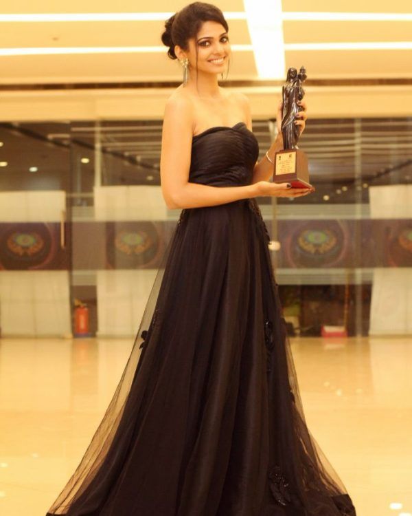 Pooja Sawant posing with the award