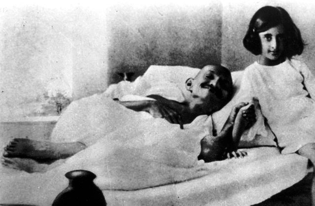 Indira Gandhi sitting beside Mahatma Gandhi