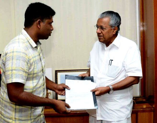 Kannan Gopinathan presenting a cheque of 1 Crores towards the Kerala CM Disaster Relief Fund