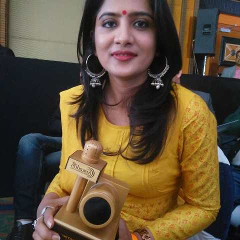 Neha Batham holding an award
