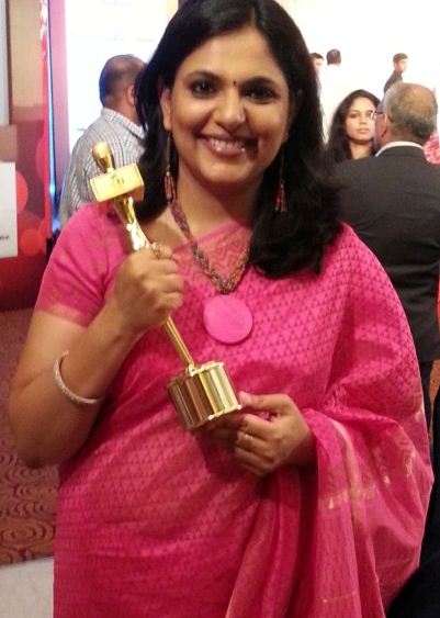Richa Anirudh holding an award