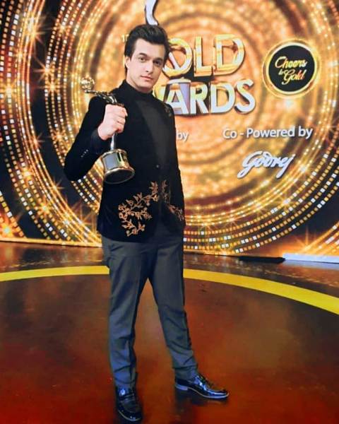 Mohsin Khan posing with an award