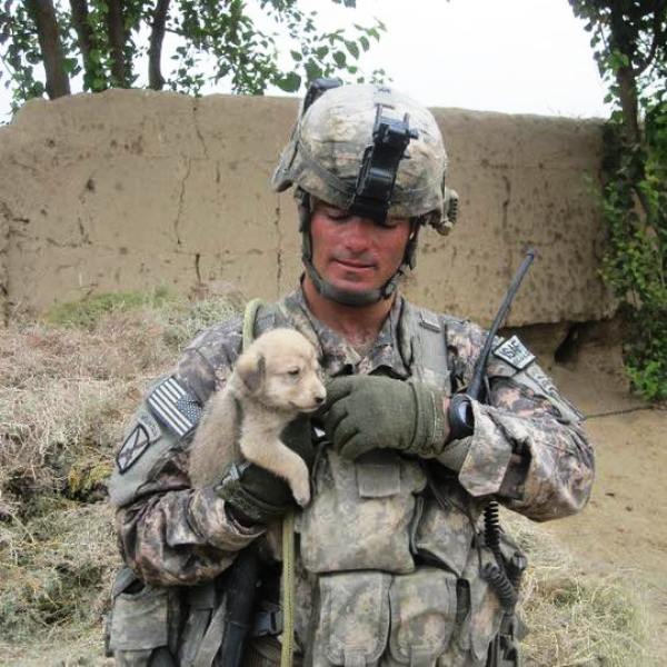 Brian Eisch Cuddling a Dog in Afghanistan