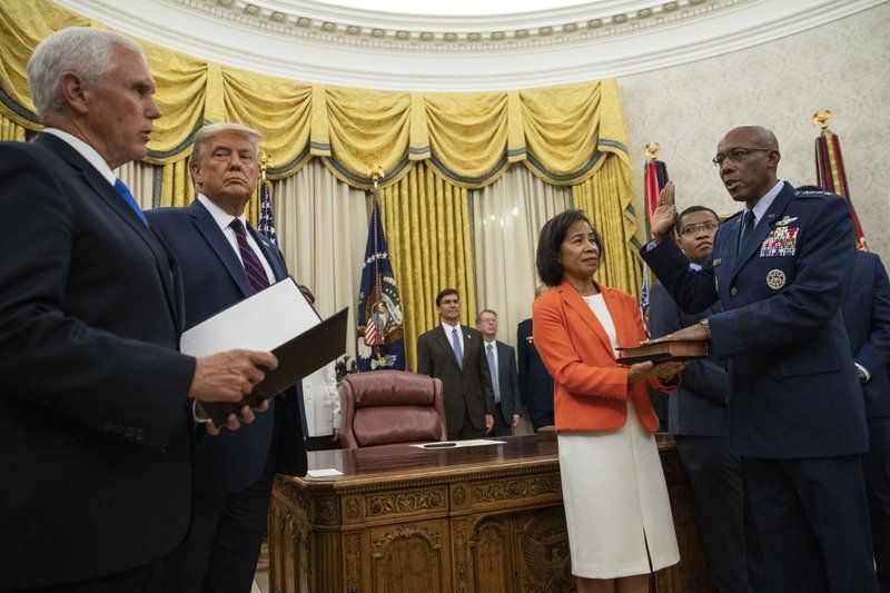 Gen. Charles Q. Brown Jr. taking oath as Chief of Staff of the Air Force as his wife holds the Bible in the Oval Office of the White House