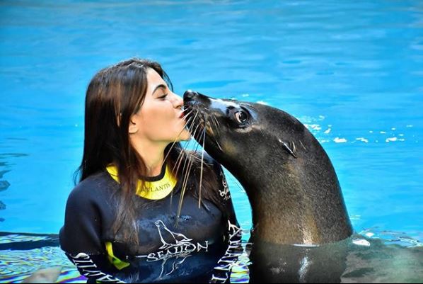 Nikki Tamboli kissing a sea lion