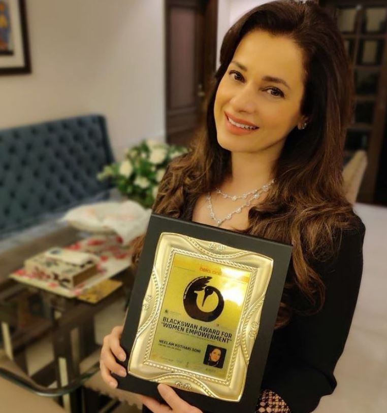 Neelam Kothari posing with her award