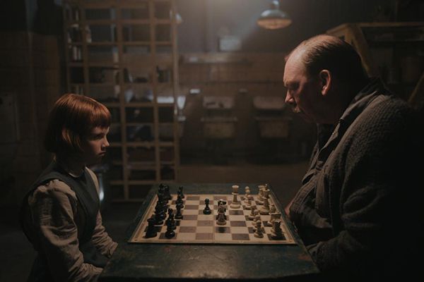 Beth Harmon (played by Isla Johnston) playing chess with William Shaibel (played by Bill Camp) in a scene from The Queen's Gambit (2020)