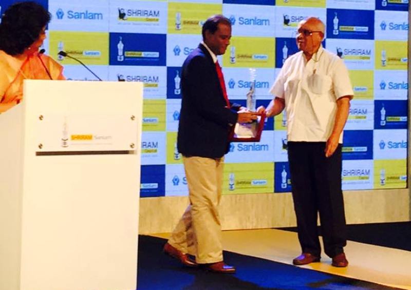 Debashis Basu receiving an award for Excellence in Financial Journalism