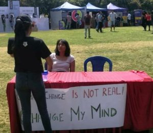 Disha Ravi sitting on a bench challenging people to debate on global climate change issue