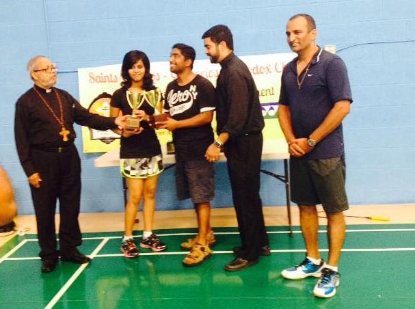 Michelle Ann Daniel receiving a trophy for winning a badminton competition in her school