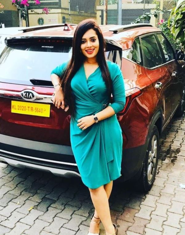 Remya Panicker standing with her car