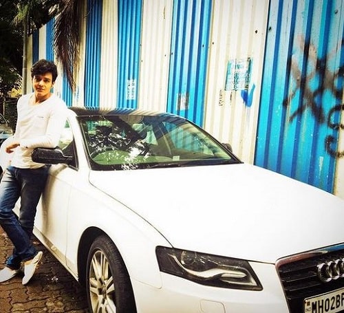Aniruddh Dave posing with his car