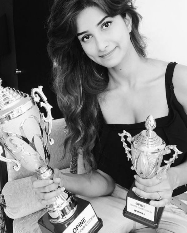 Diksha Singh holding her school trophies