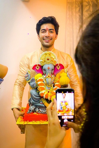 Akshay Kharodia holding an idol of Lord Ganesha