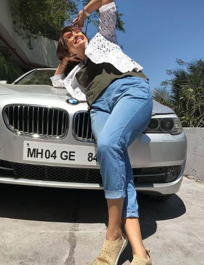 Nisha Rawal posing with her car