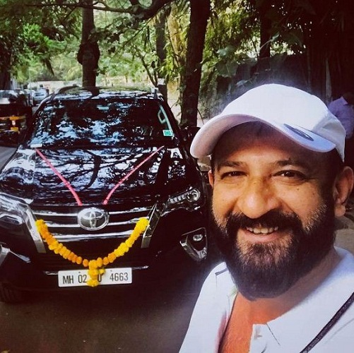 Raj Kaushal posing with his Toyota Fortuner car