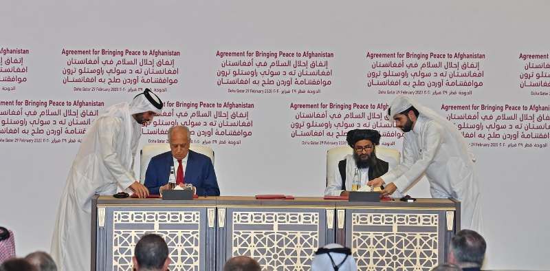 US representative Zalmay Khalilzad (left) and Baradar (right) sign the Agreement for Bringing Peace to Afghanistan in Doha, Qatar, on 29 February 2020