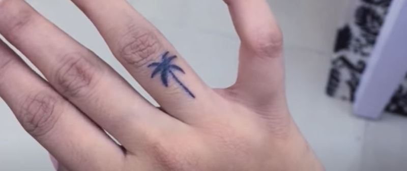 Larissa tattooed a Palm Tree on her right hand ring finger