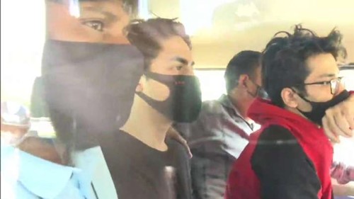 Aryan Khan and Arbaaz Merchant (red hoodie) with NCB officials after their arrest