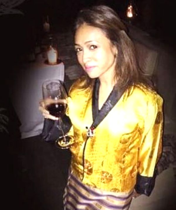 Surily Goel holding a glass of wine