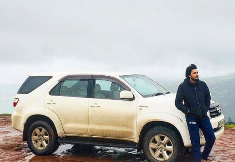 Chirag posing with his Fortuner