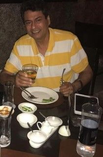 Kanwaljit holding a glass of whiskey