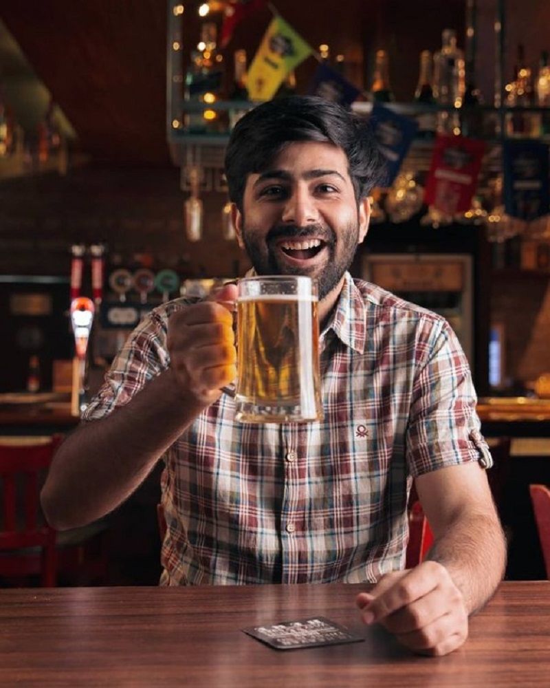 Kapil holding a glass of beer