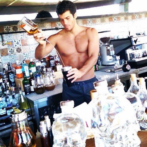Can Yaman holding a bottle of alcohol