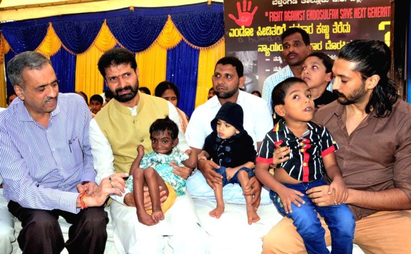 Chetan Kumar holding a Endosulfan victim during `Fight against Endosulfan Save Next Generation`- an awareness campaign, in Bengaluru, on Nov 18, 2015