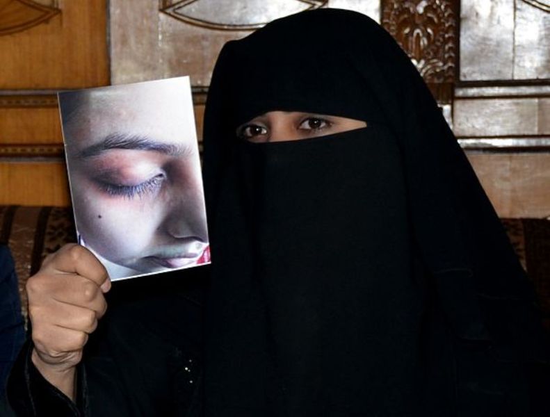 Nida Khan, displaying photograph of her wounds as evidence of domestic violence during a press conference