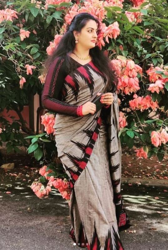 Suchithra Nair posing in front of flowers