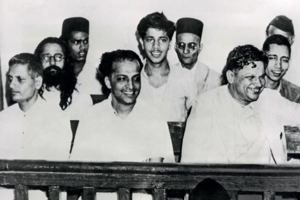Vinayak Savarkar (wearing a black cap, behind Nathuram Godse and his fellow accused) at the Mahatma Gandhi assassination trial at the special court at the Red Fort, 27 May 1948.