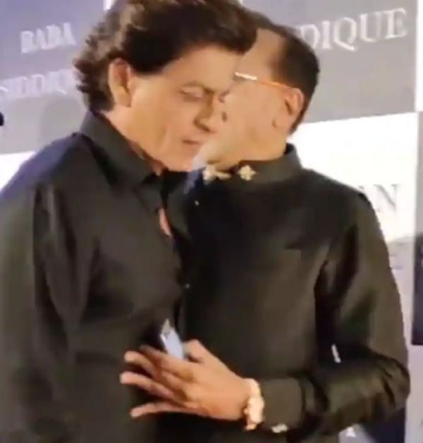 Baba Siddique pushing Shah Rukh Khan to pose with him for media
