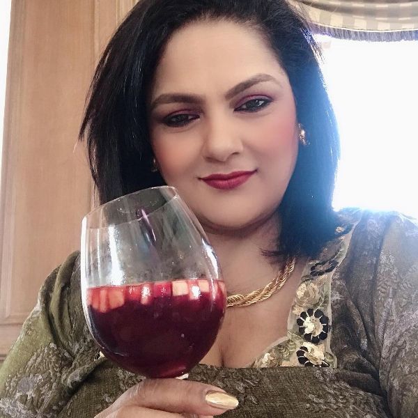Guddi Maruti is seen holding a glass of wine