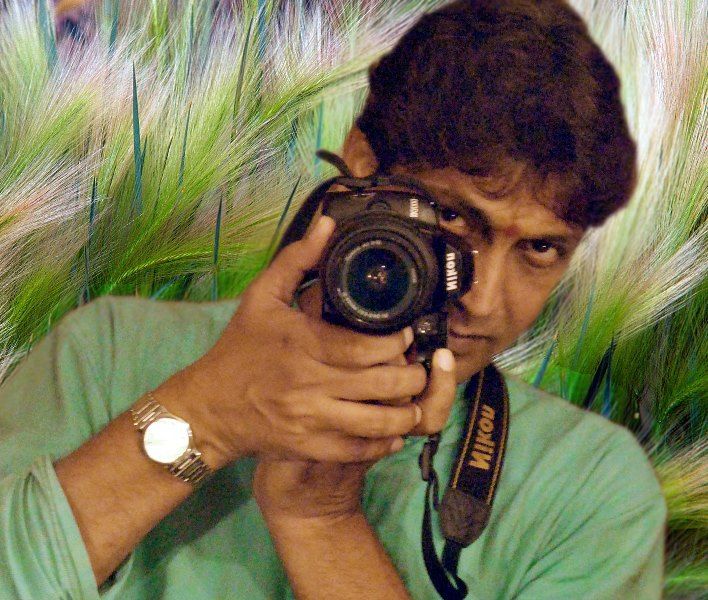 Makarand posing as a photographer with a camera in his hand