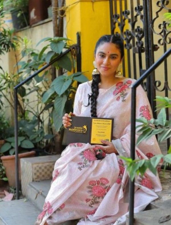 Priya Malik posing with her Outstanding Contribution to Indian Literature Award at the Iconic Achievers Awards 2022