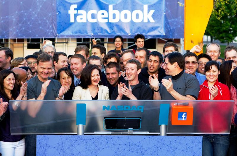 Mark Zuckerberg (centre) and Sheryl Sandberg (left) applauding after remotely ringing the opening bell for trading at the Nasdaq