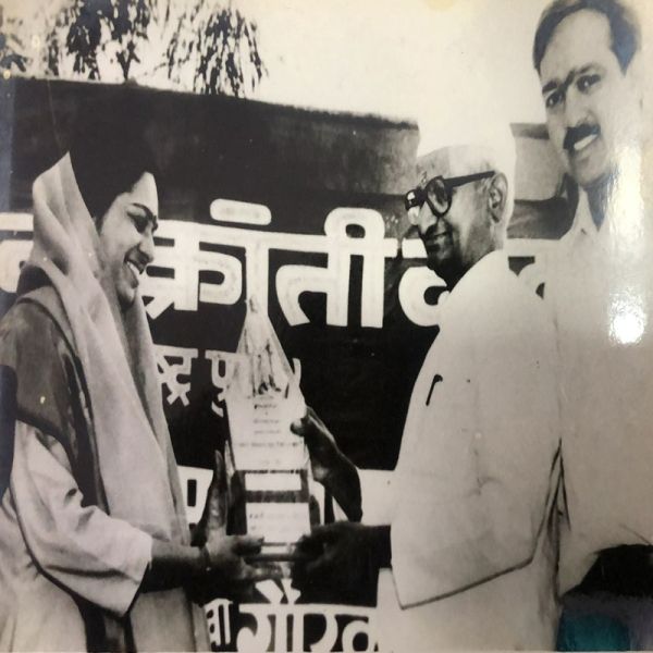 Rajani Pandit receiving an award from Anna Hazare