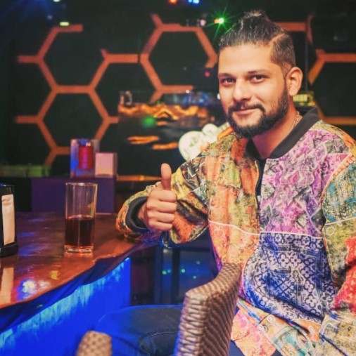 Rakesh Adiga with a glass of alcohol