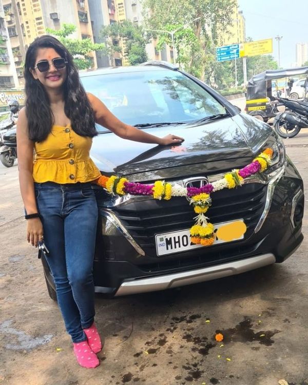 Megha Chakraborty posing with her brand new car