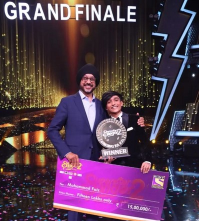 Mohammad Faiz posing with the cash prize after winning Superstar Singer Season 2 in 2022
