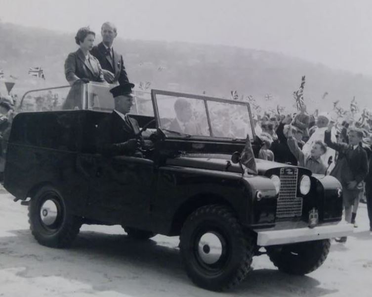 Queen Elizabeth II with Prince Charles riding on Land Rover Series I