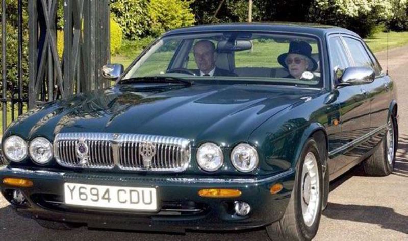 Queen Elizabeth in Jaguar Daimler V8 Super LWB car with her husband, Prince Philip, driving the car