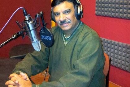 Shammi Narang posing with a microphone in a recording studio