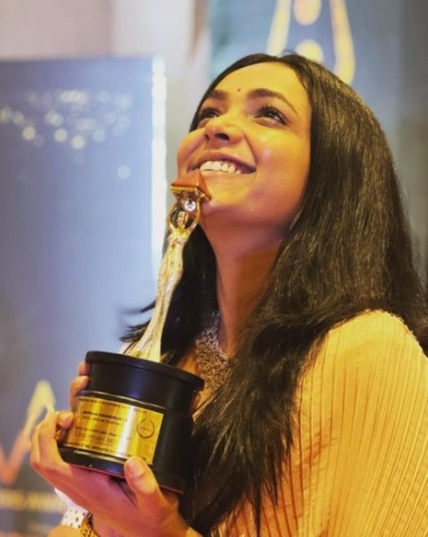A photo of Anupama Gowda with the KWAA award