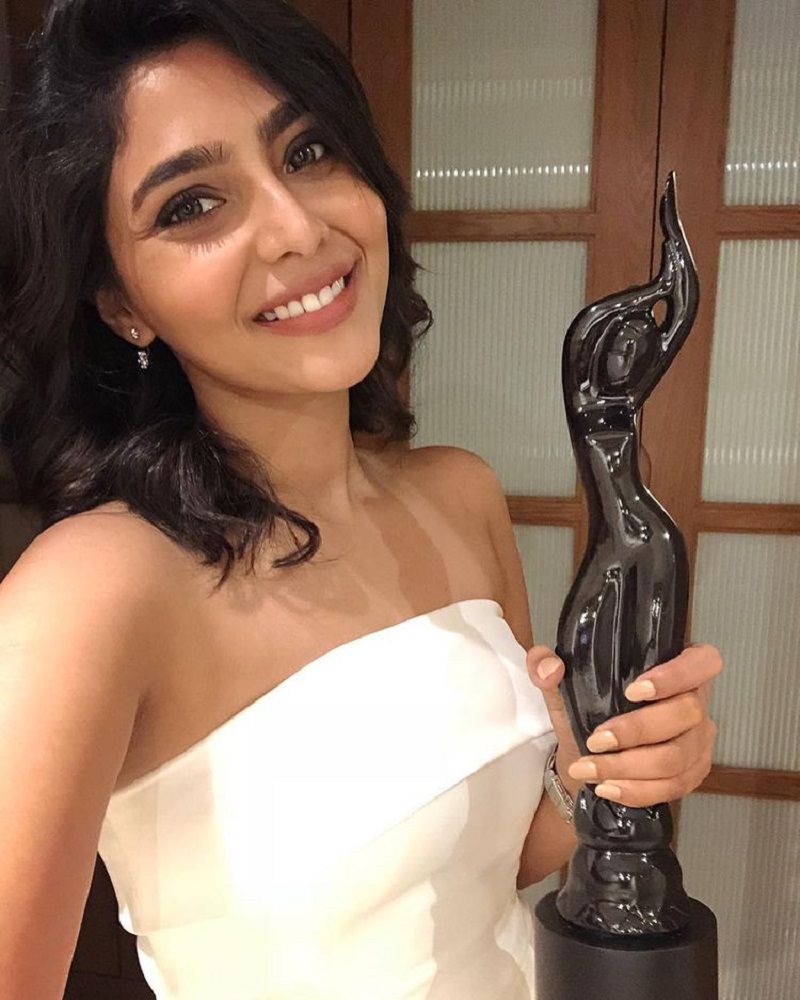 Aishwarya Lekshmi posing with best female debut award for the film Njandukalude Nattil Oridavela at 65th Filmfare Awards South